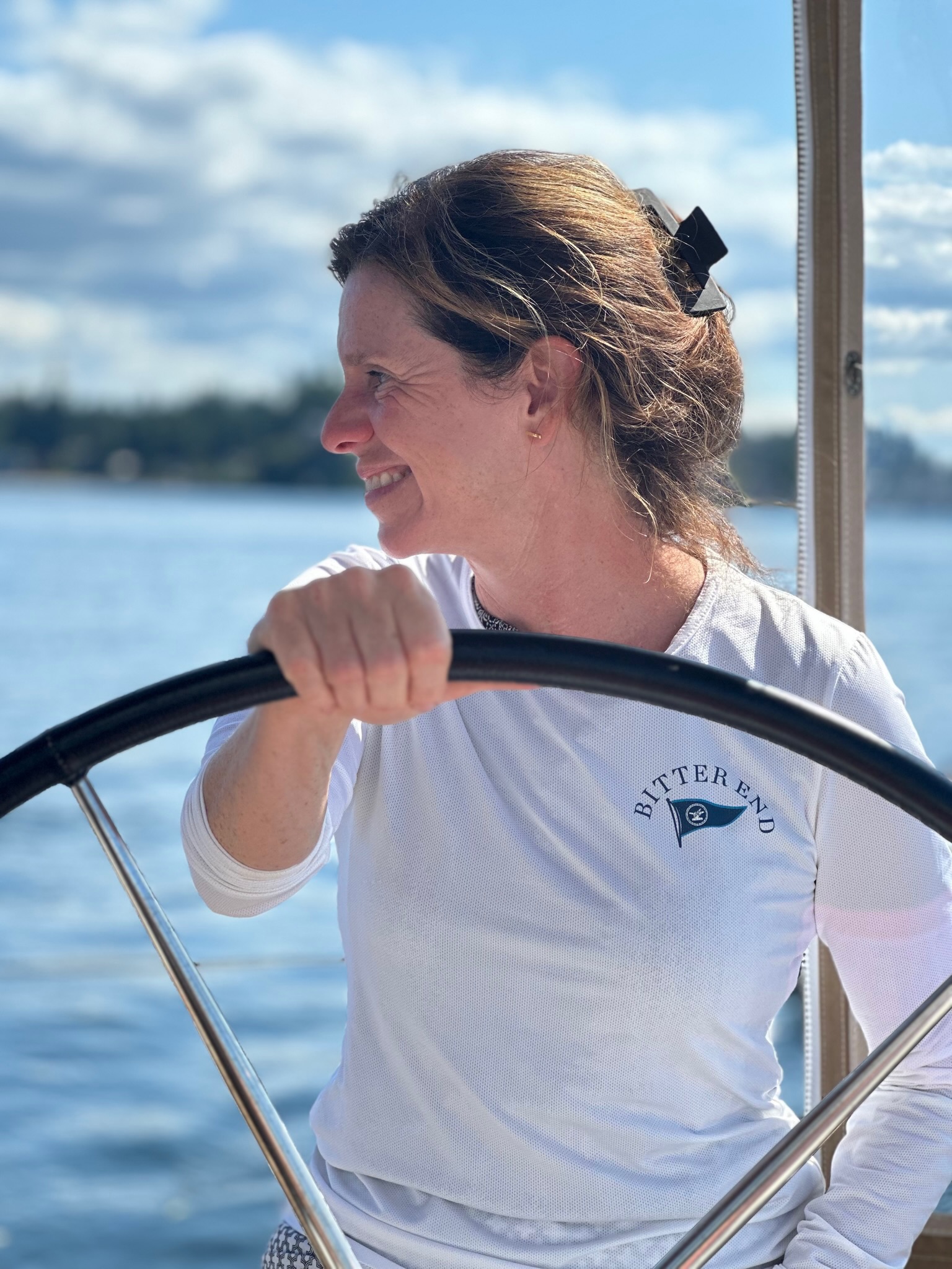 Beth smiling at the helm on the water.