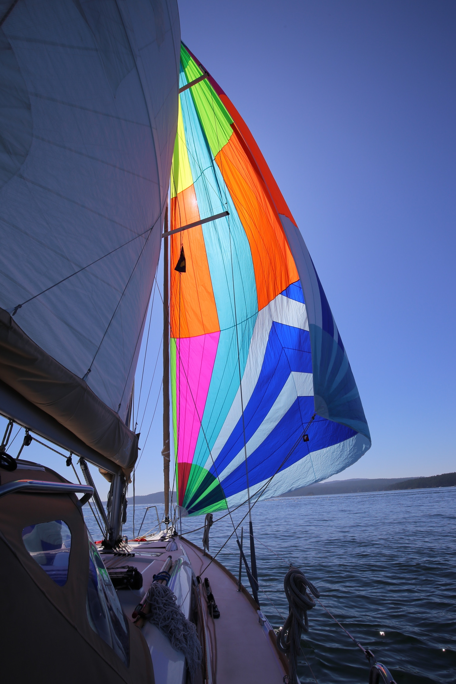 A colorful spinnaker flying above the water.