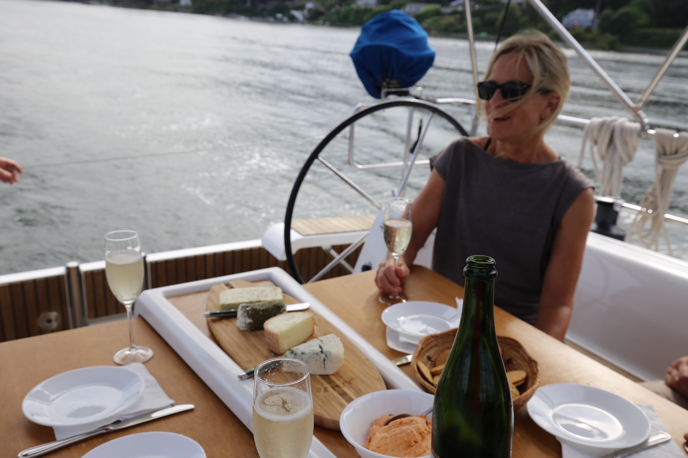 A guest seated at the cockpit table with lunch set out.