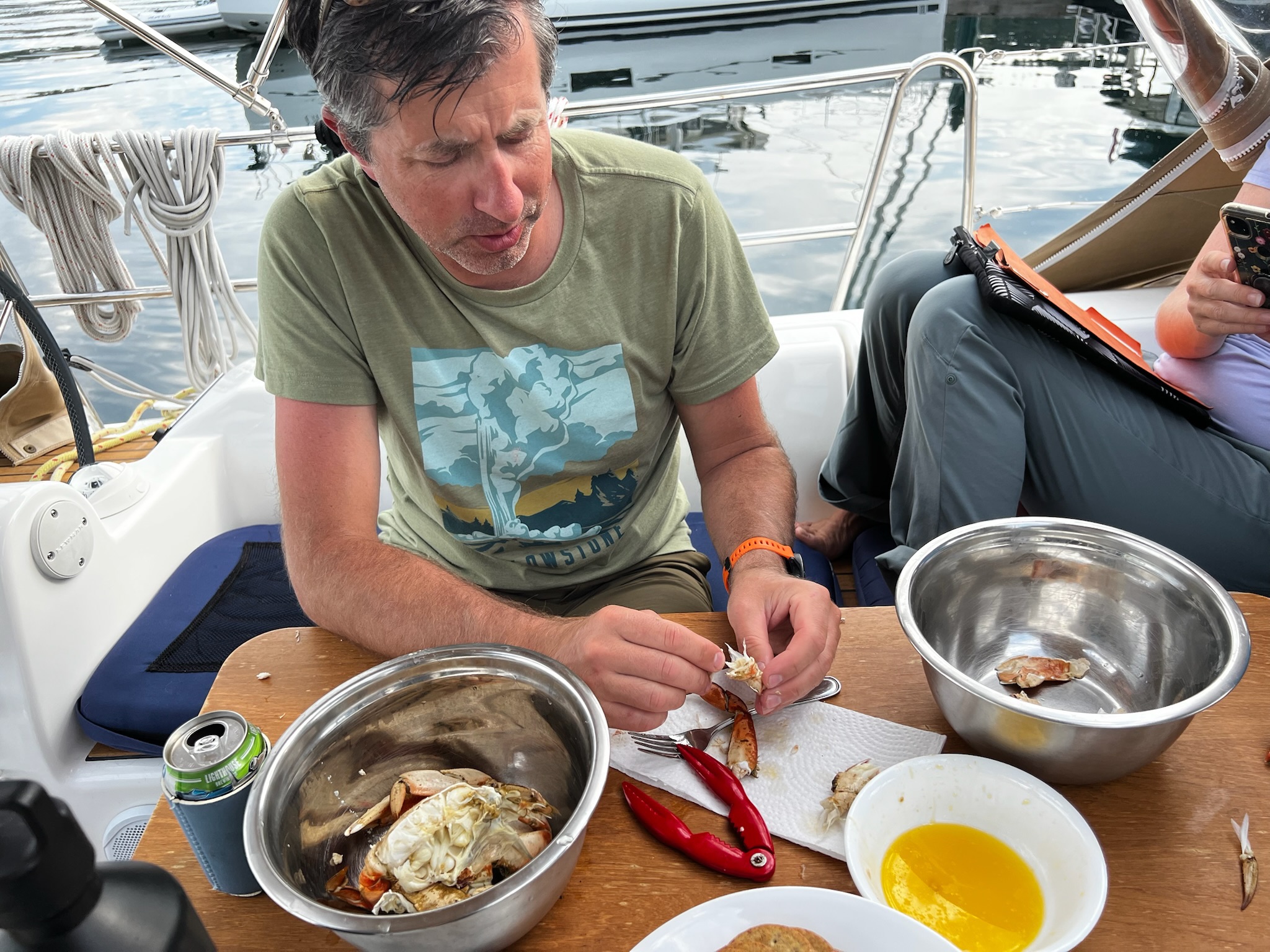 A guest preparing oysters at the cockpit table.